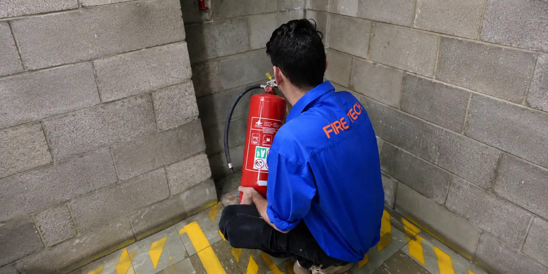 Fire technician checking extinguisher location and safety readiness onsite.